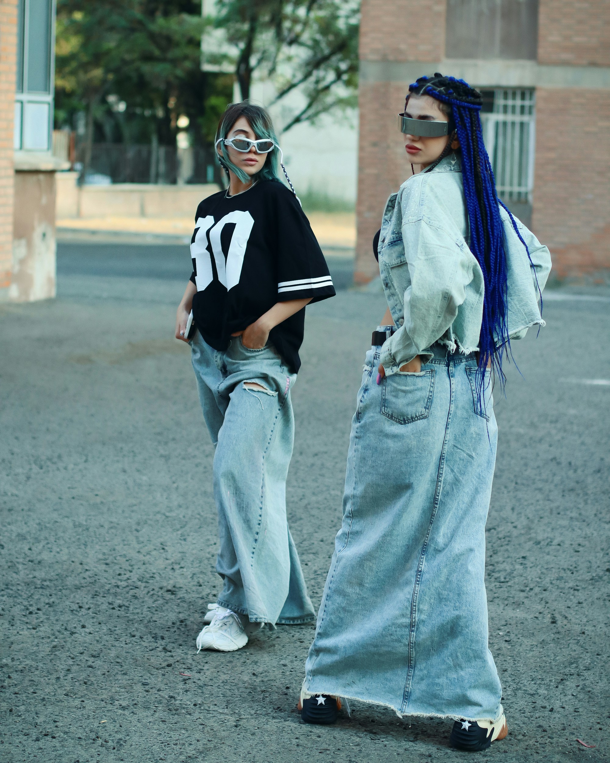Two women standing in the middle of a parking lot