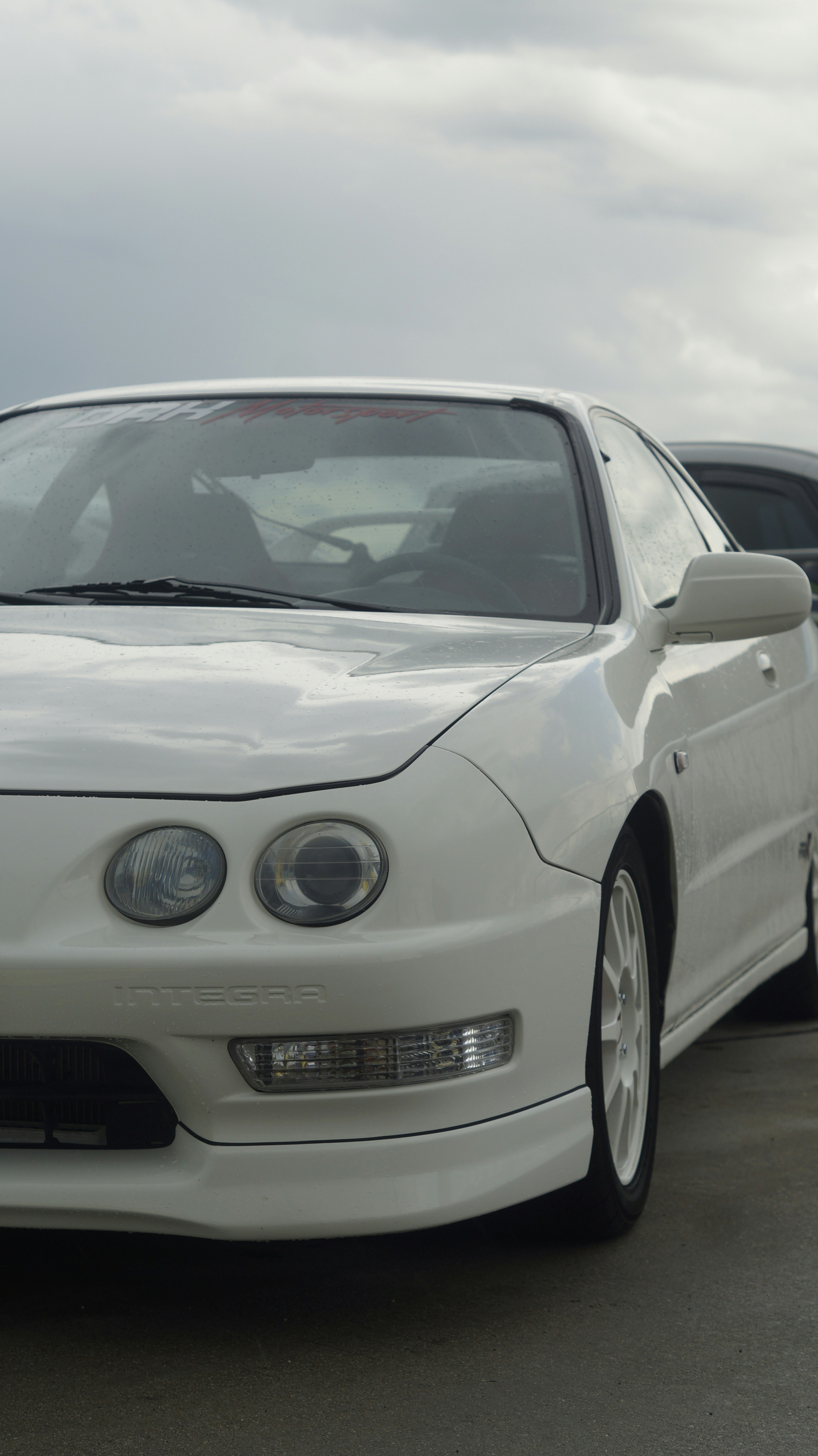A white car is parked in a parking lot