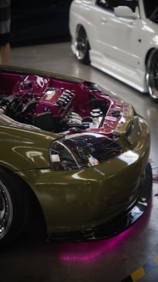 A green sports car parked next to a white car