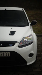 A white car parked on a brick road