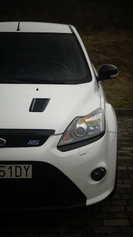 A white car parked on a brick road