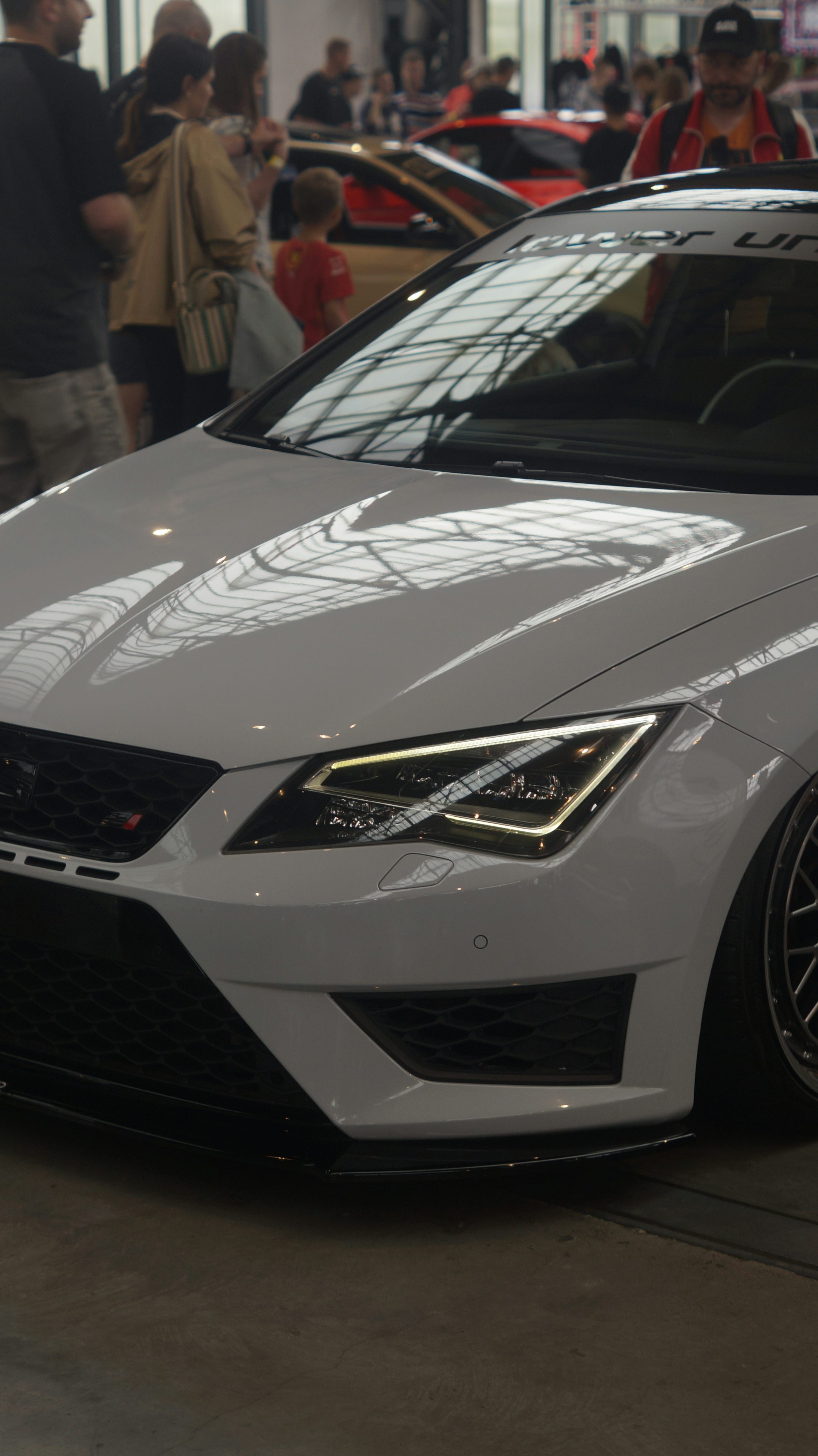 A white car is parked in a showroom