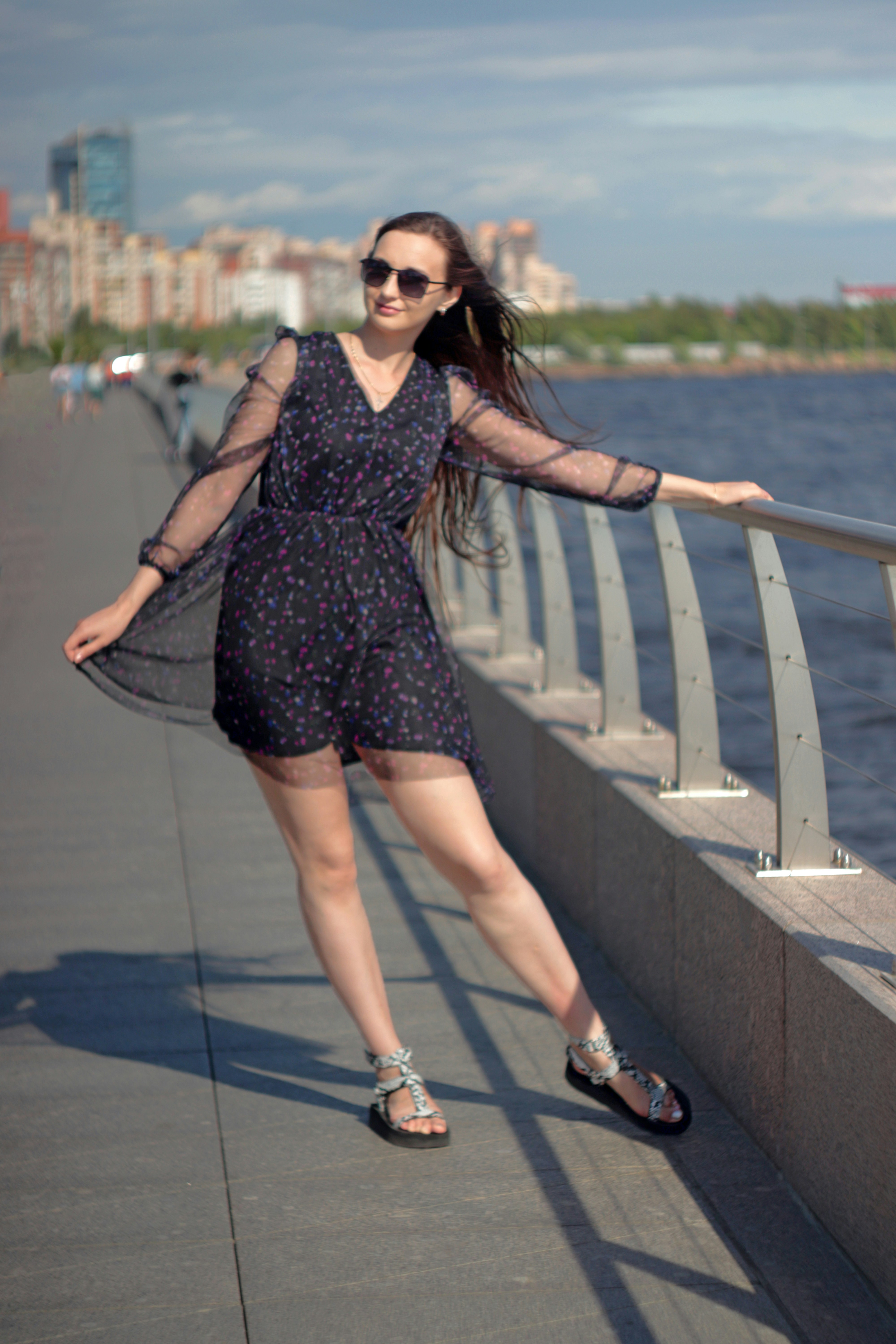 Una mujer apoyada en una barandilla cerca del agua