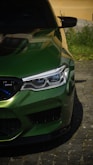 A close up of a green car parked on a street
