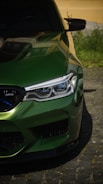 A close up of a green car parked on a street
