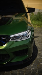 A close up of a green car parked on a street