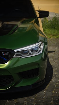 A close up of a green car parked on a street