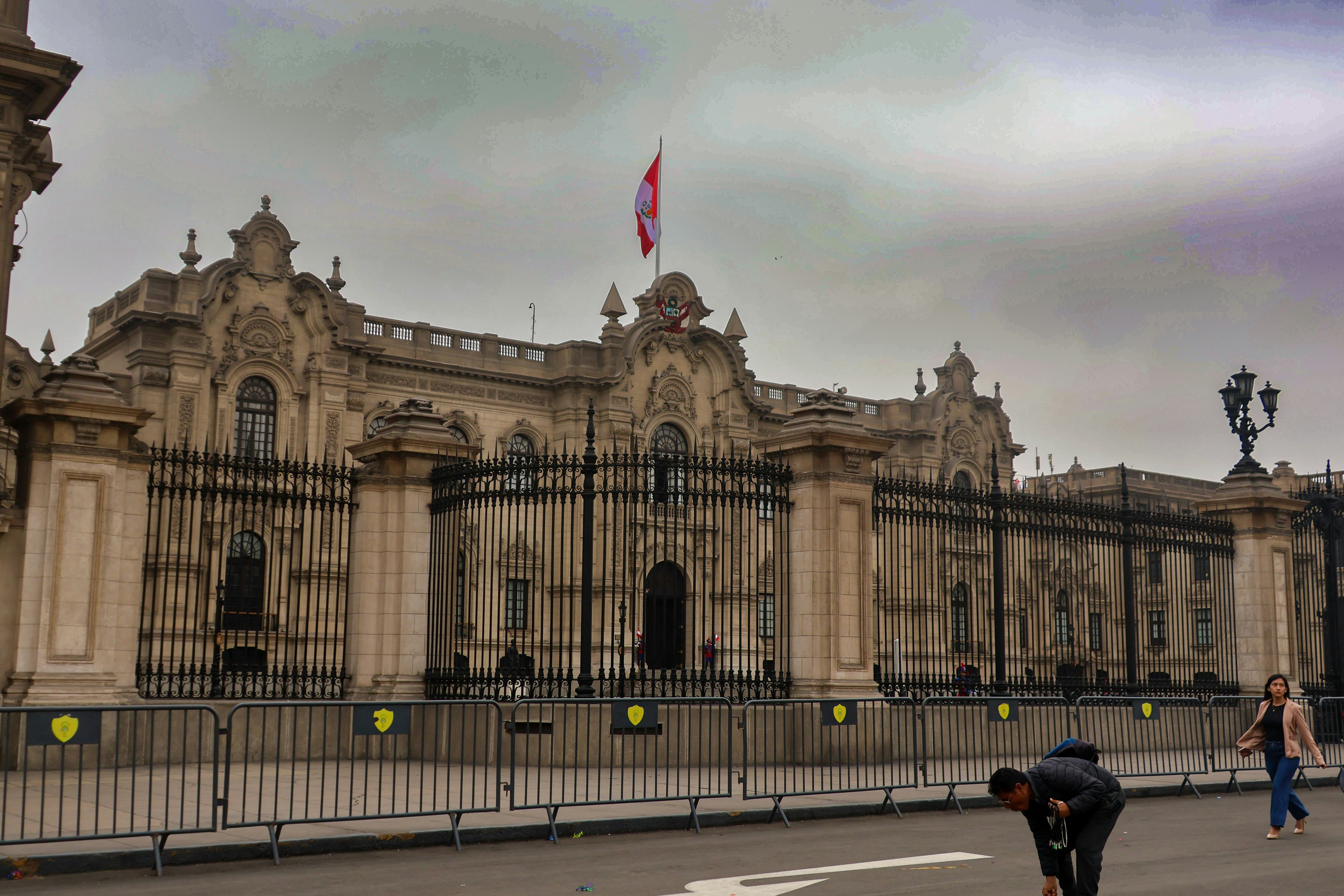 A group of people walking across a street in front of a large building