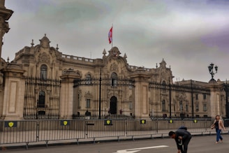 A group of people walking across a street in front of a large building