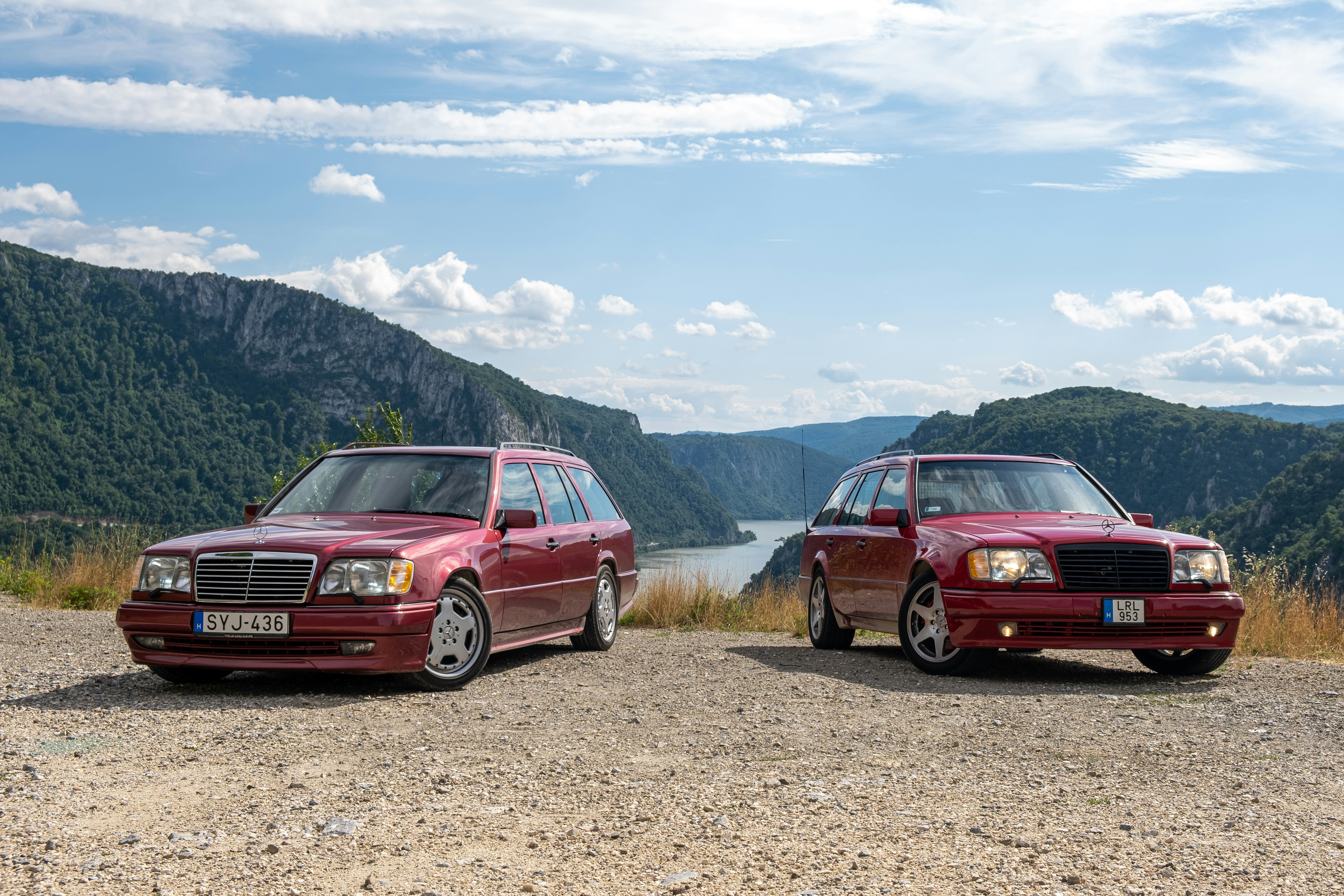 A couple of cars parked on top of a dirt road