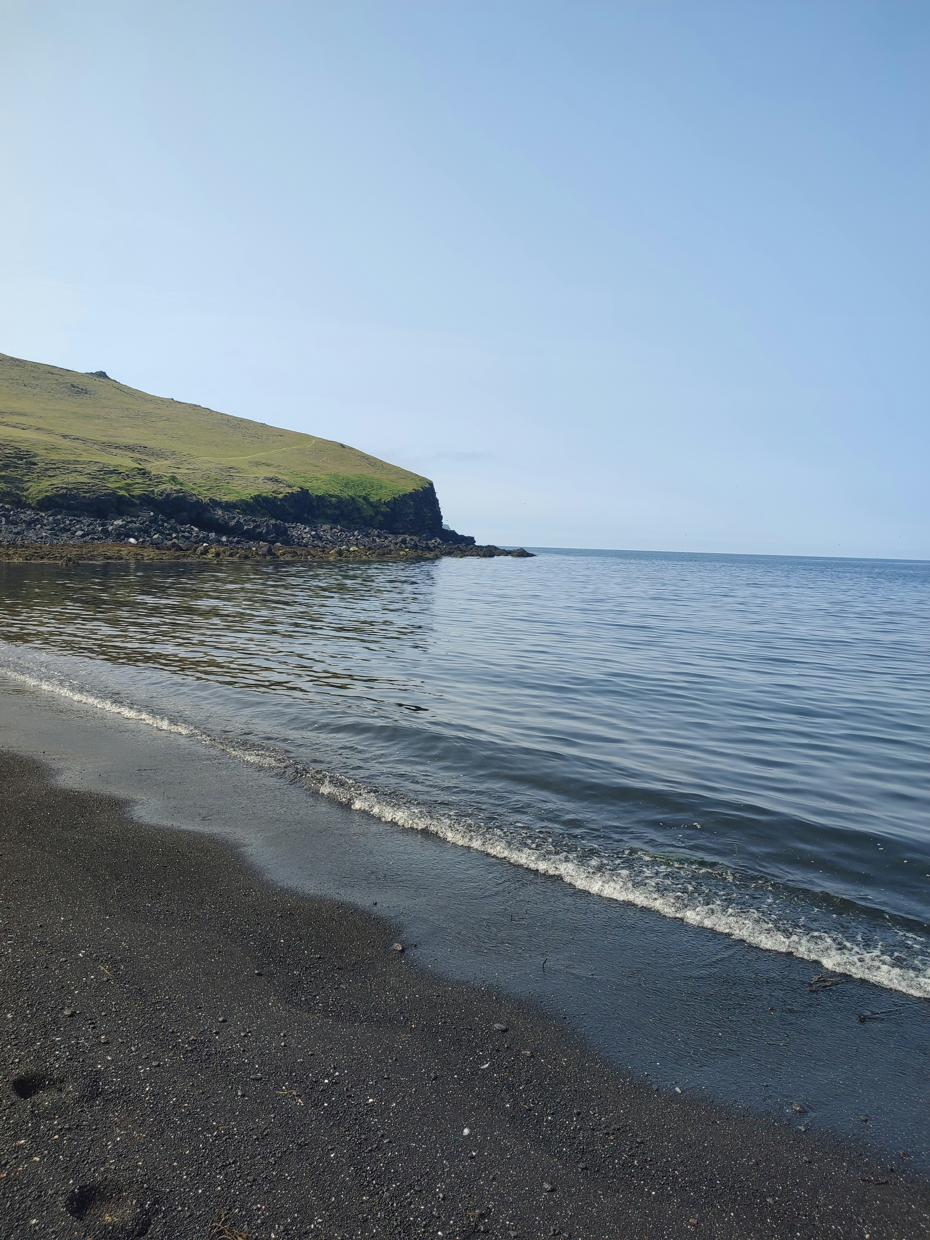 A person walking along a beach next to the ocean