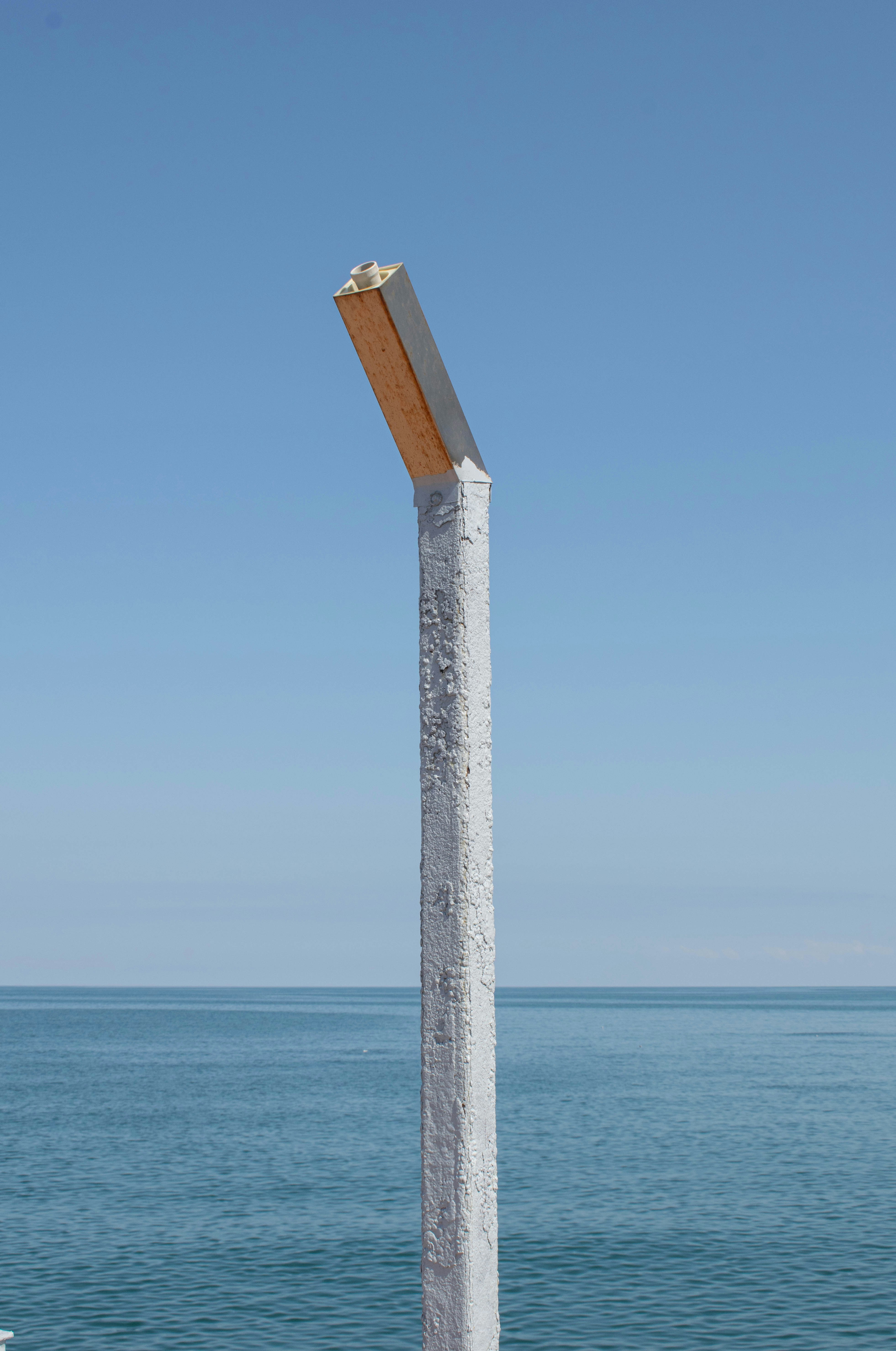 Un grand poteau blanc posé à côté d’un plan d’eau