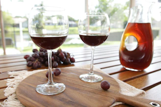 Two glasses of wine and a bottle of wine on a table