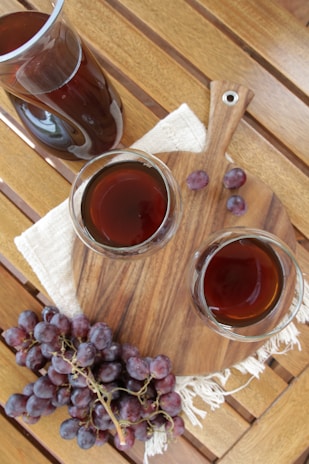 A wooden table topped with two glasses of wine