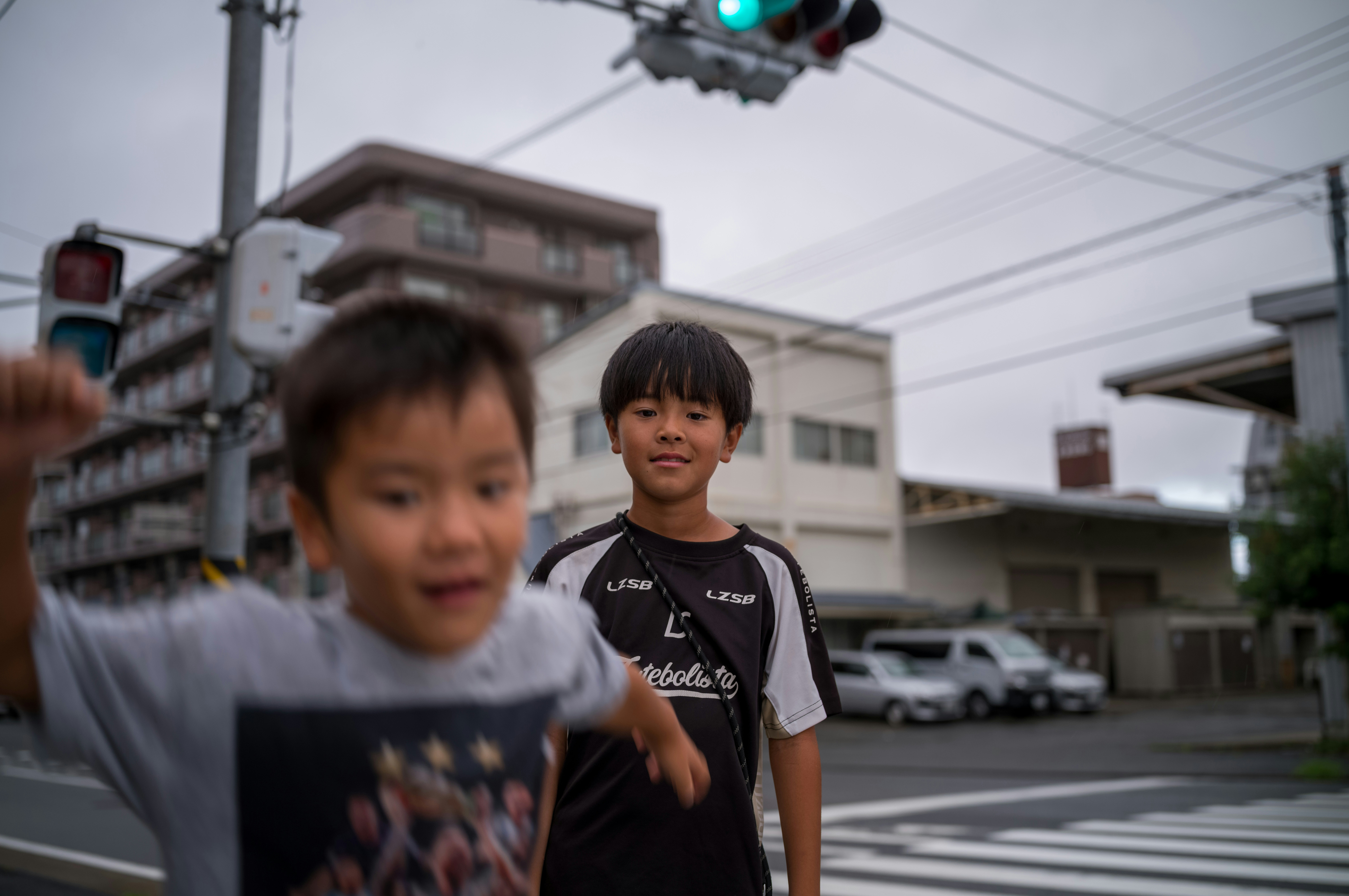 Two young boys standing in the middle of a street