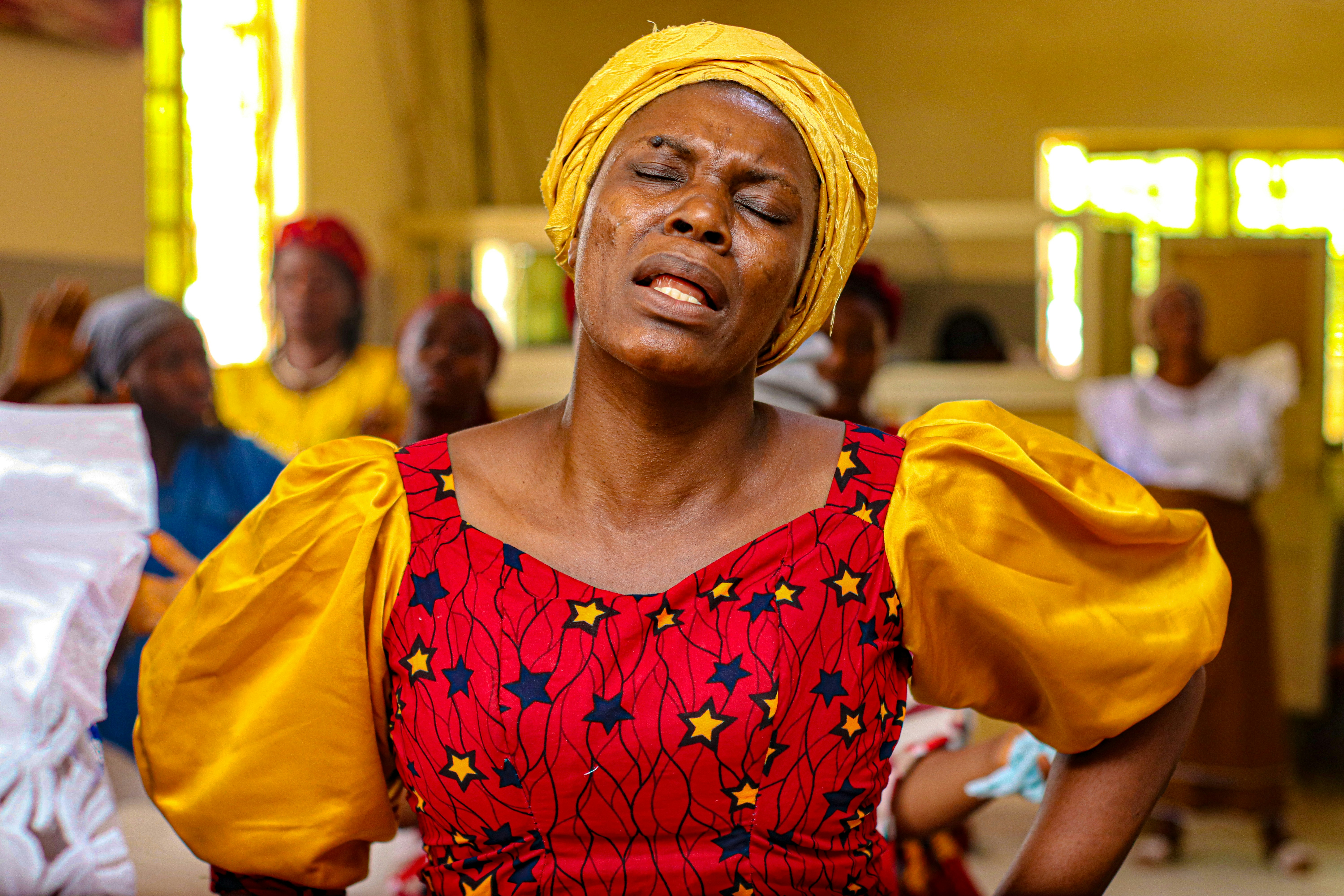 A woman with a yellow turban standing in a room