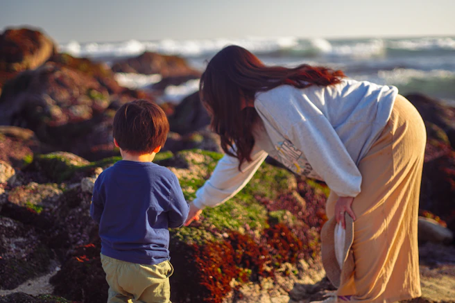 A woman and a child on a rocky beach