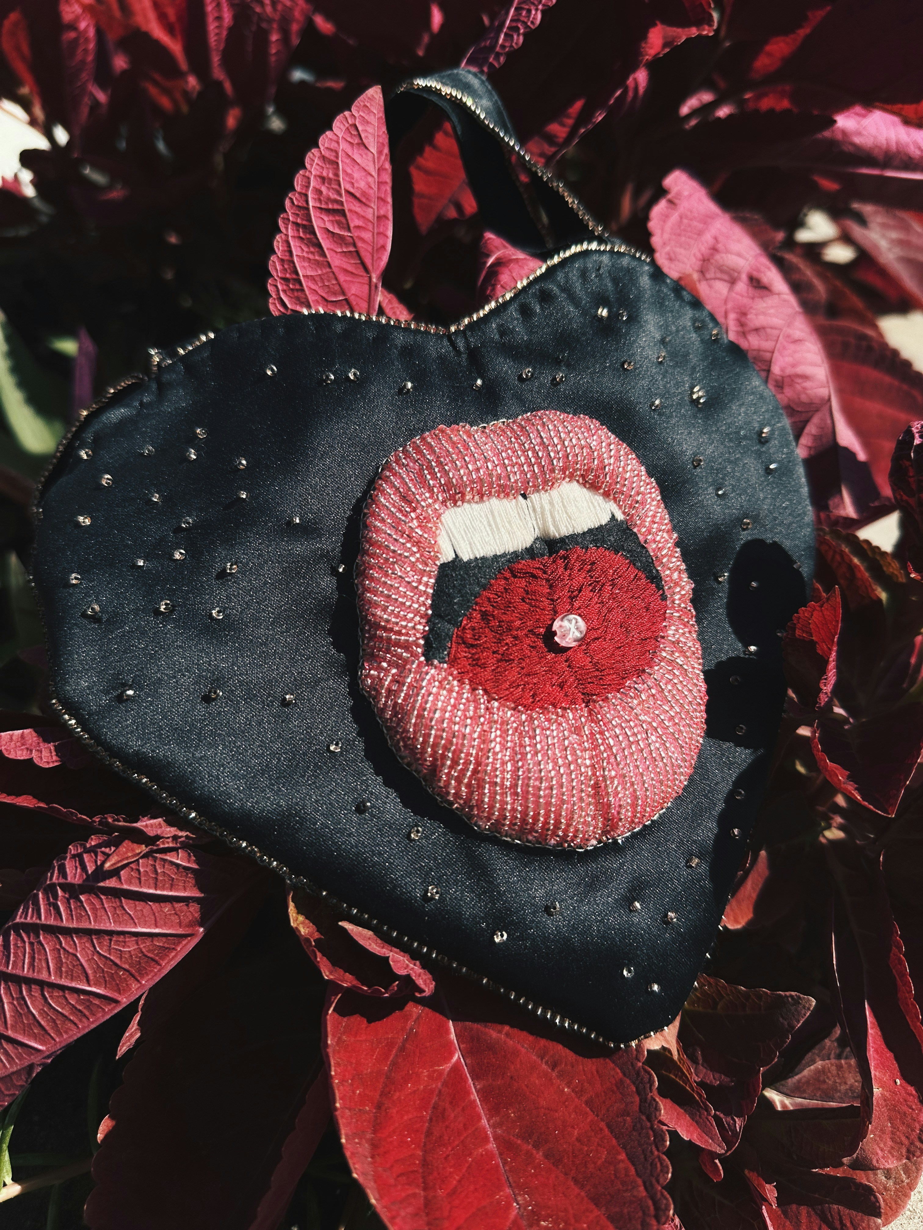 赤いリップがついた黒い財布