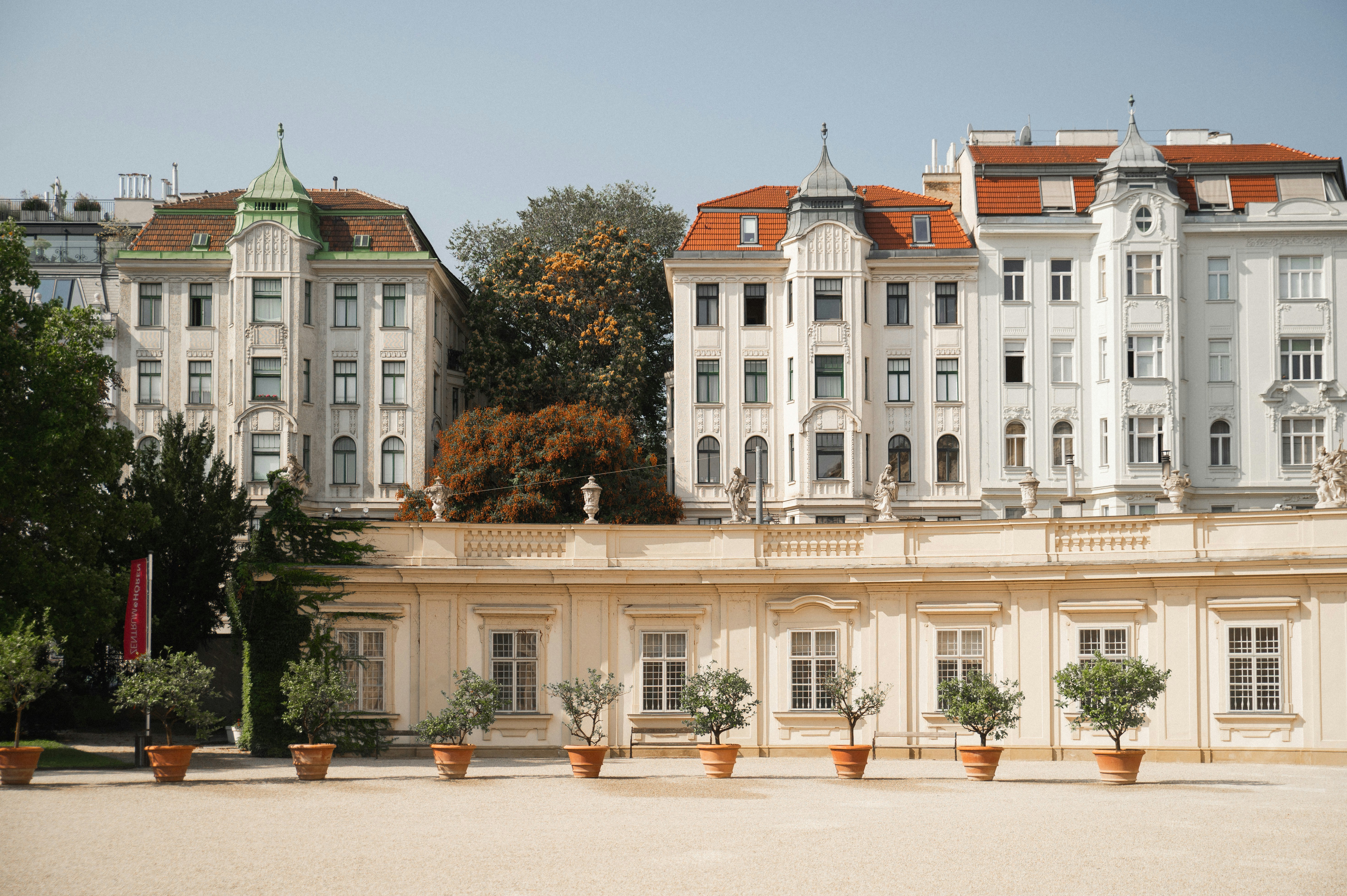 A row of white buildings in front of trees