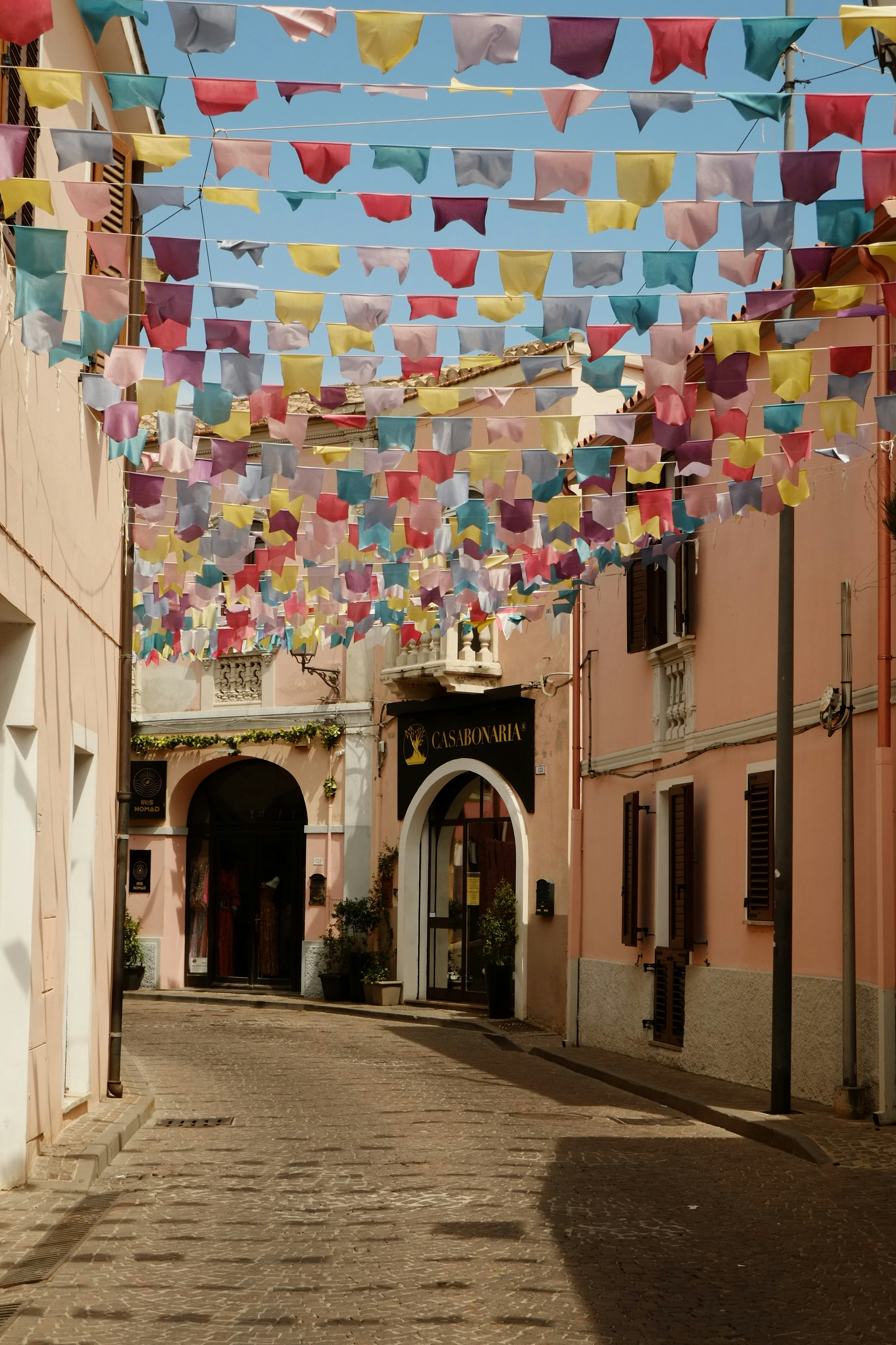 A street with a bunch of colorful flags hanging from it's sides