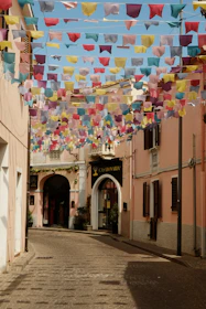 A street with a bunch of colorful flags hanging from it's sides