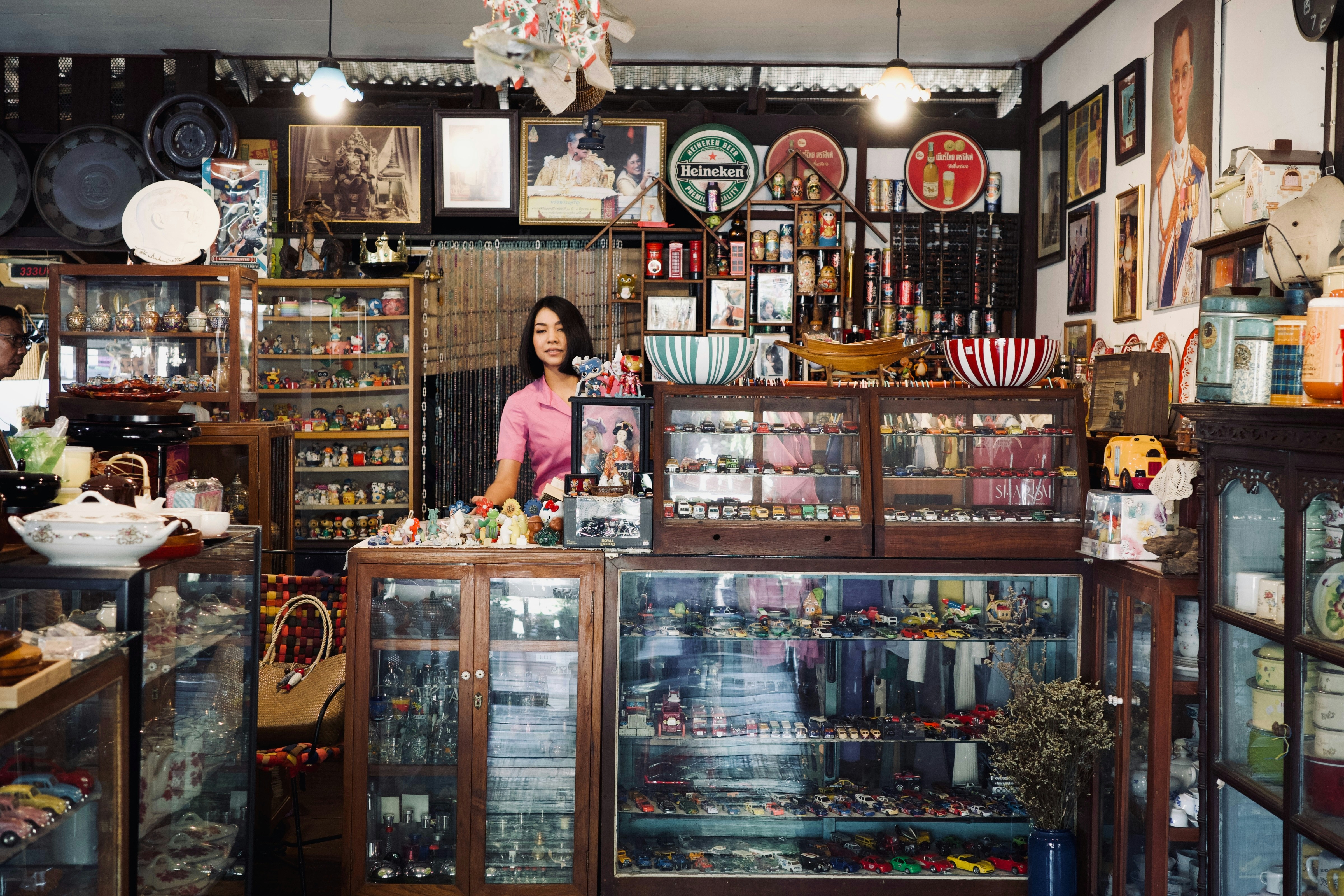 A woman standing in front of a store filled with items