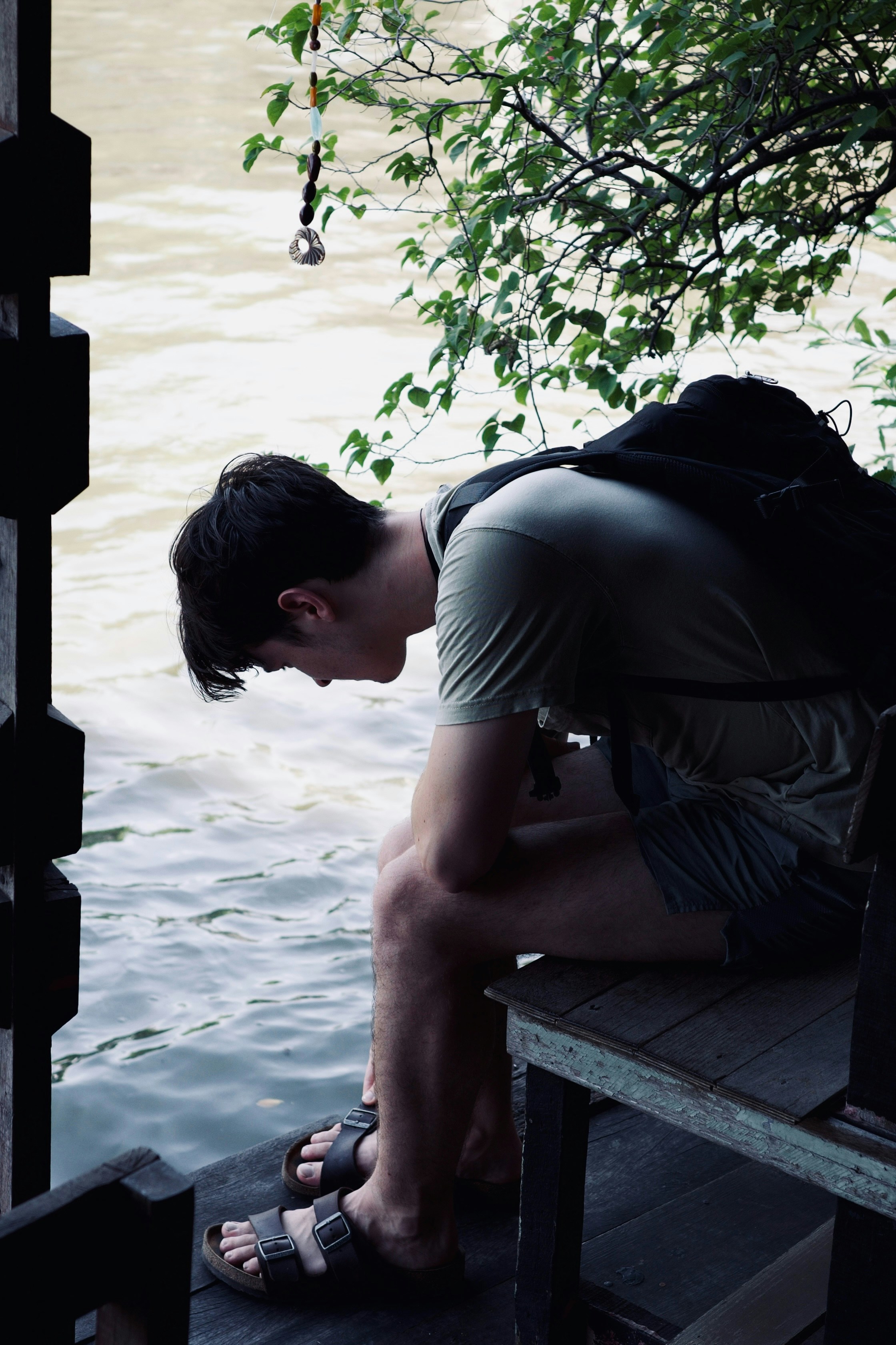 A man sitting on a bench next to a body of water