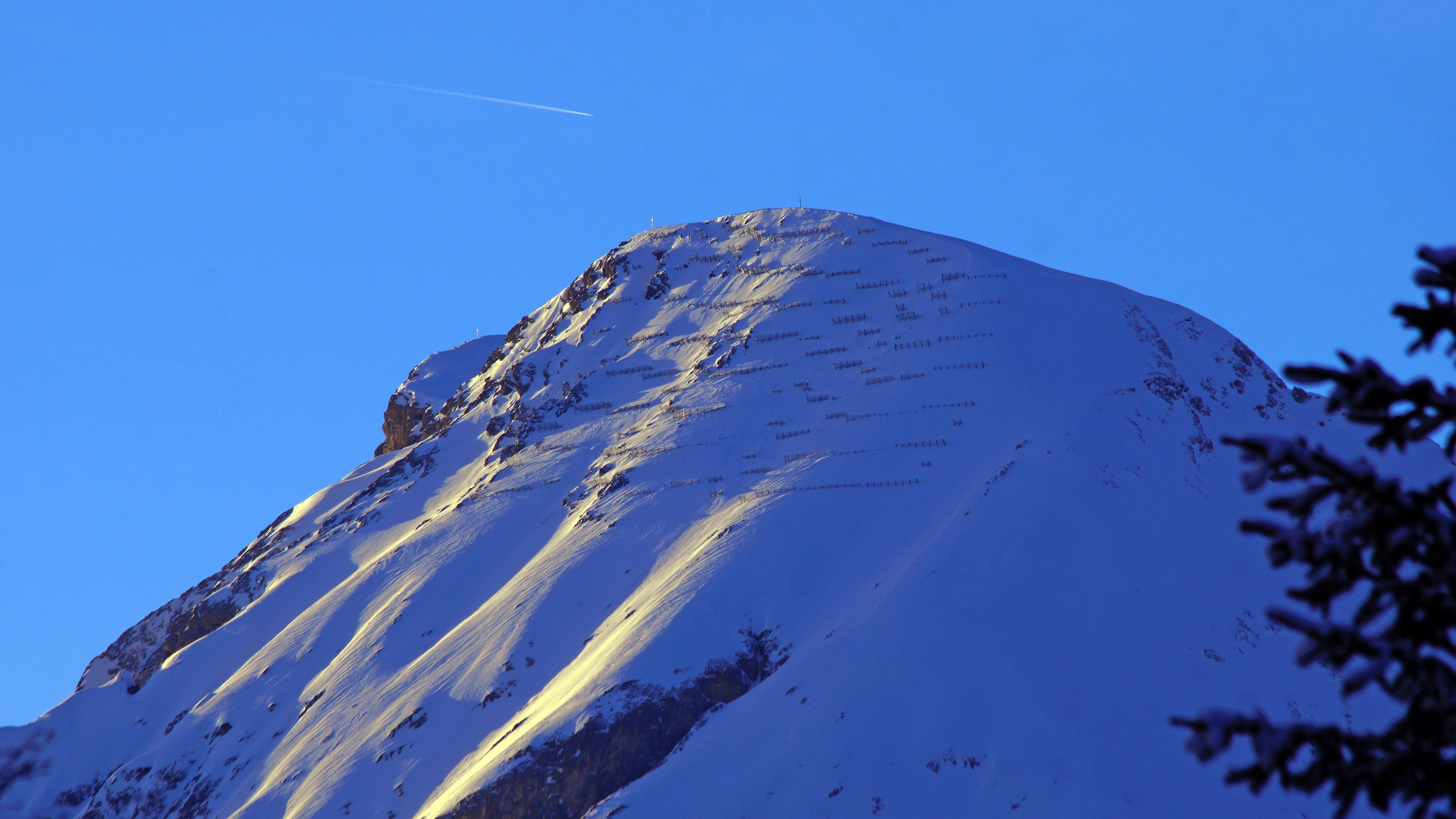 A snowboarder is doing a trick in the air, 