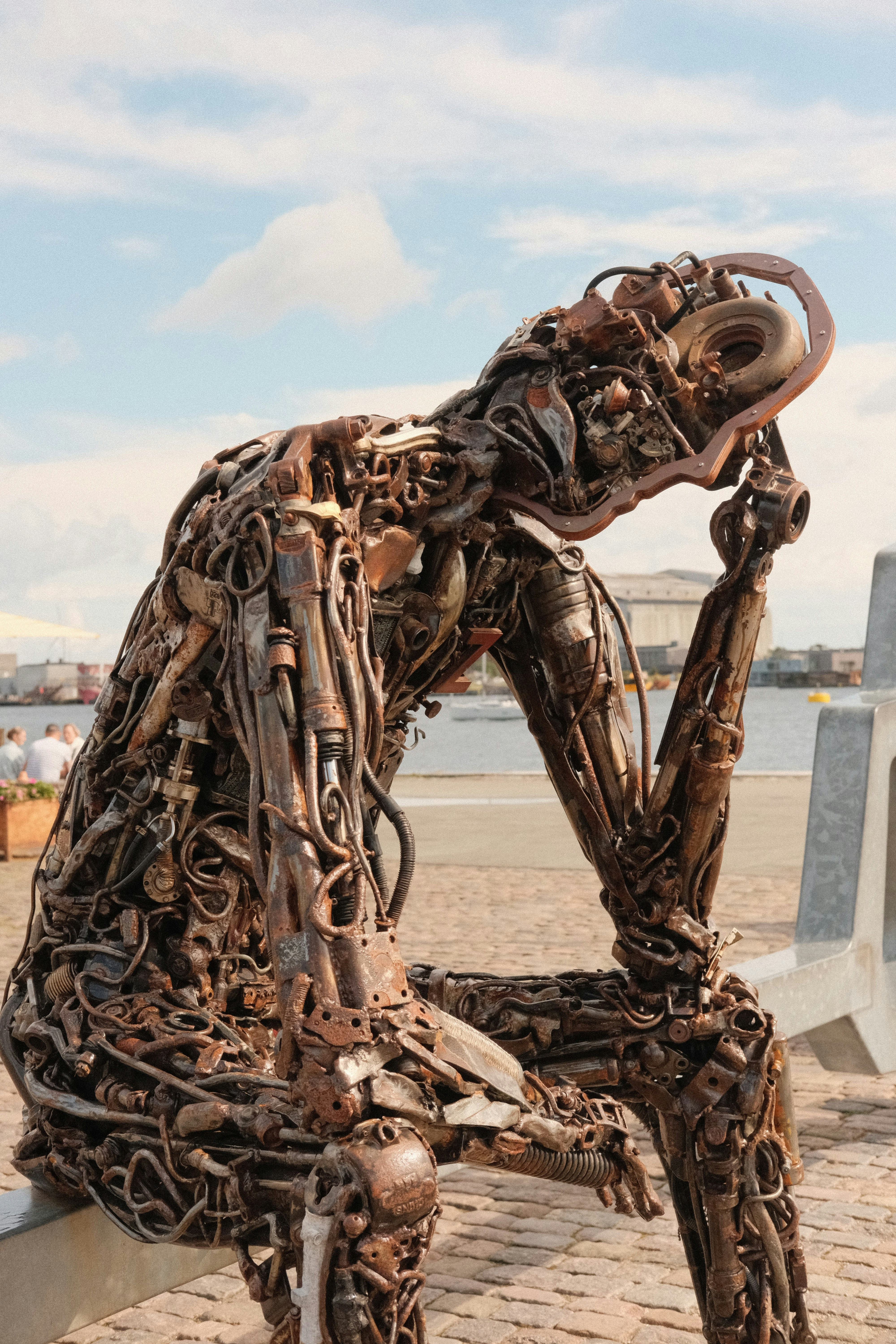 A sculpture of a person sitting on a bench