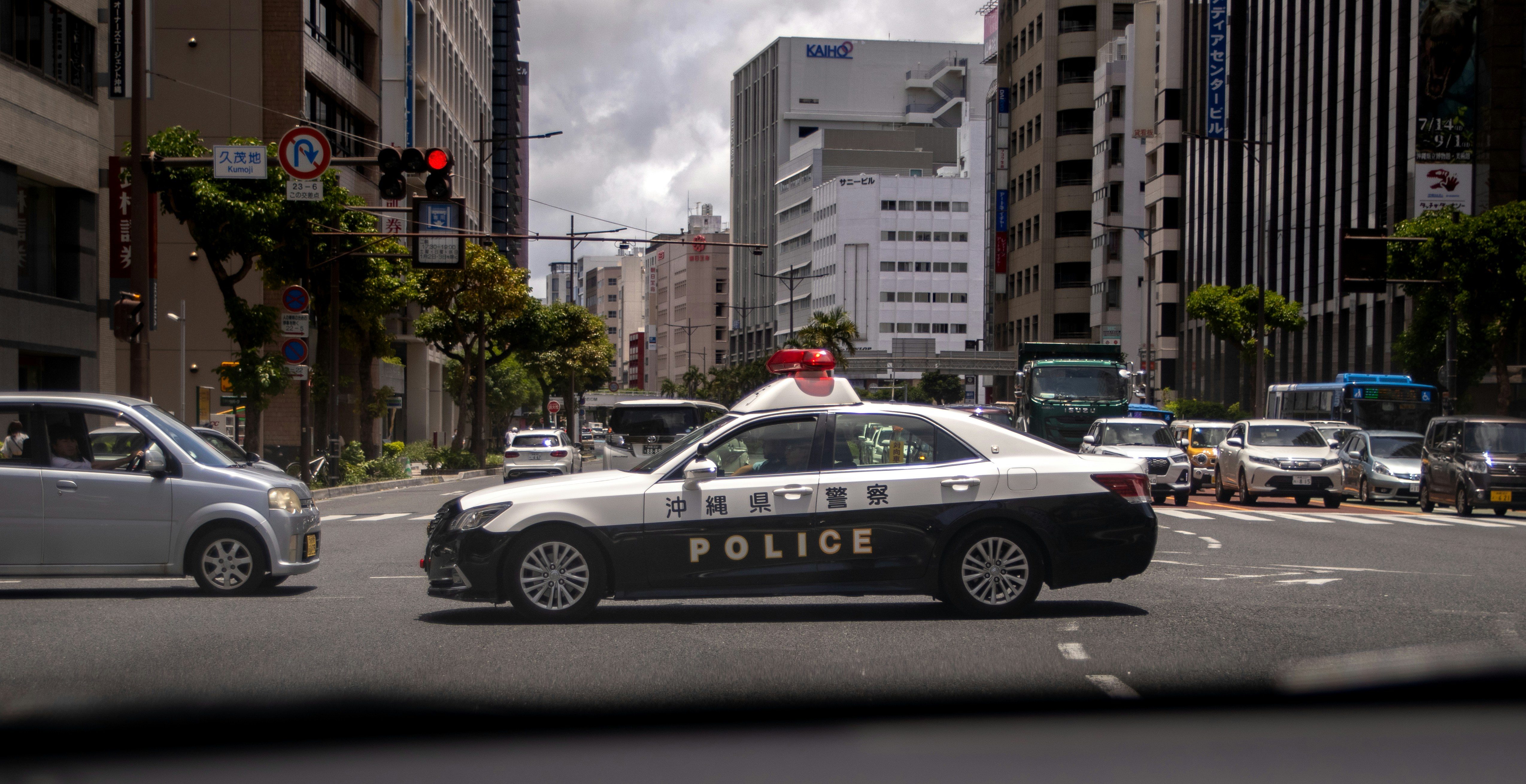 A police car driving down a street next to tall buildings