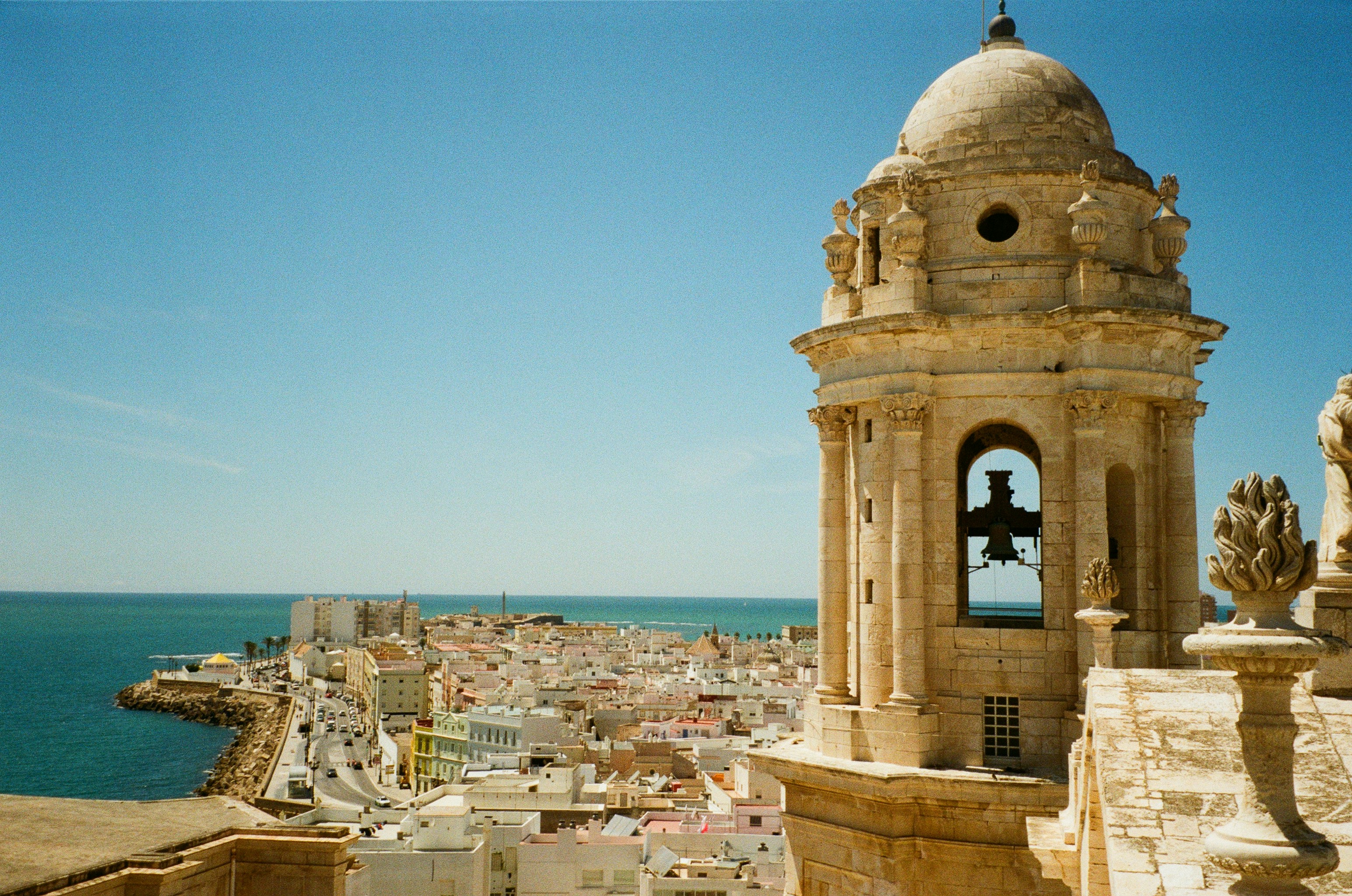 A bell tower on top of a building next to a body of water
