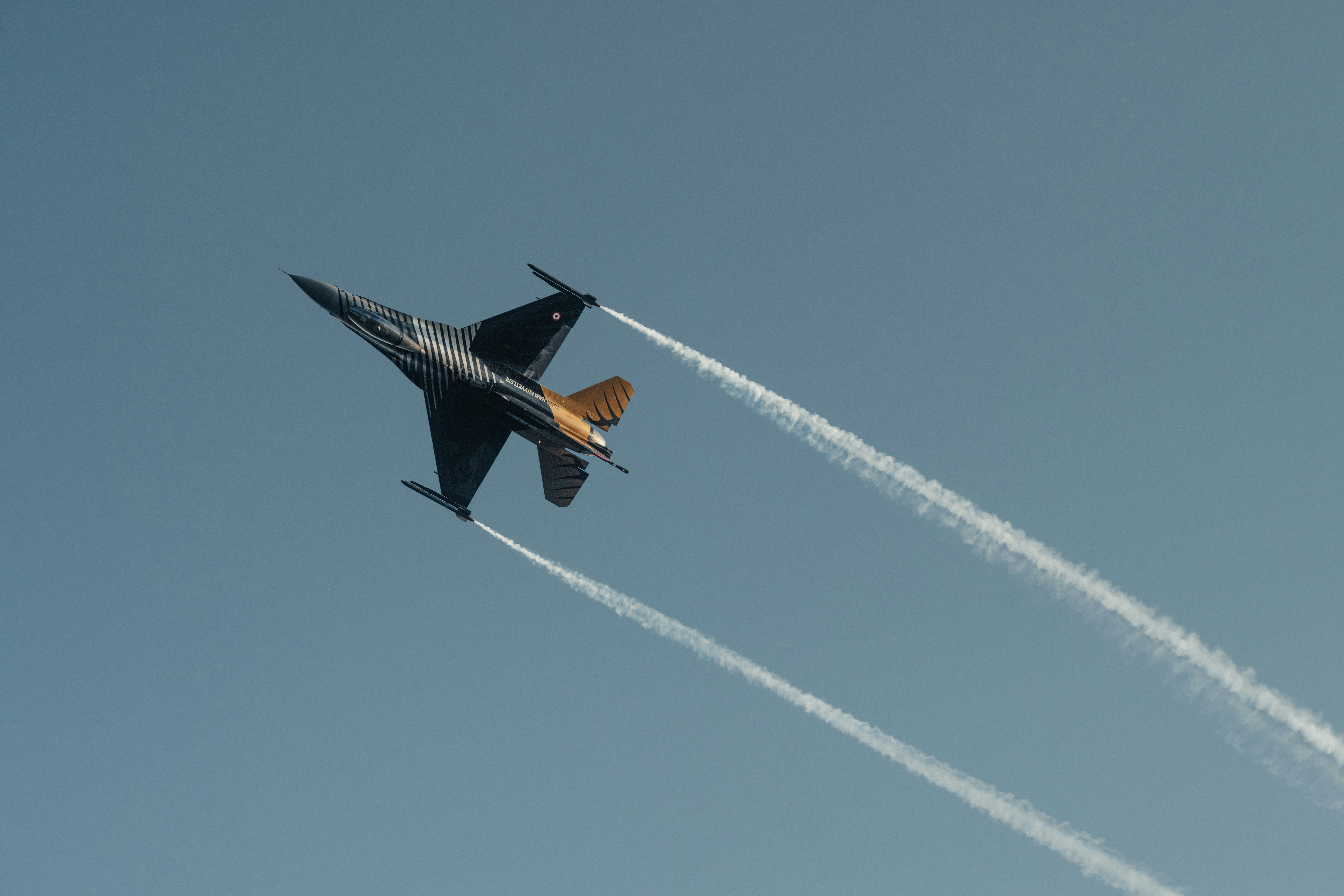 A fighter jet flying through a blue sky