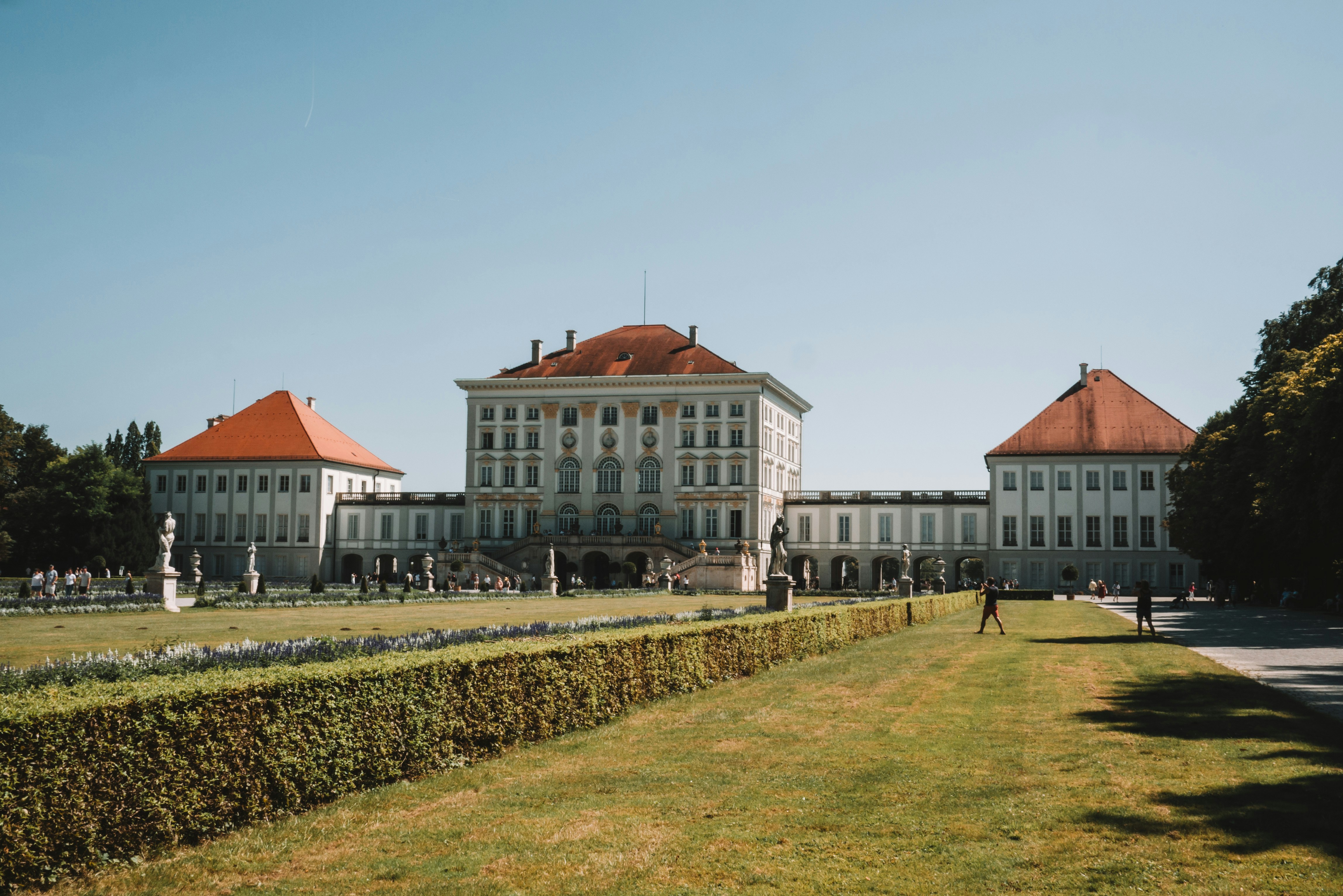 A large white building sitting next to a lush green field