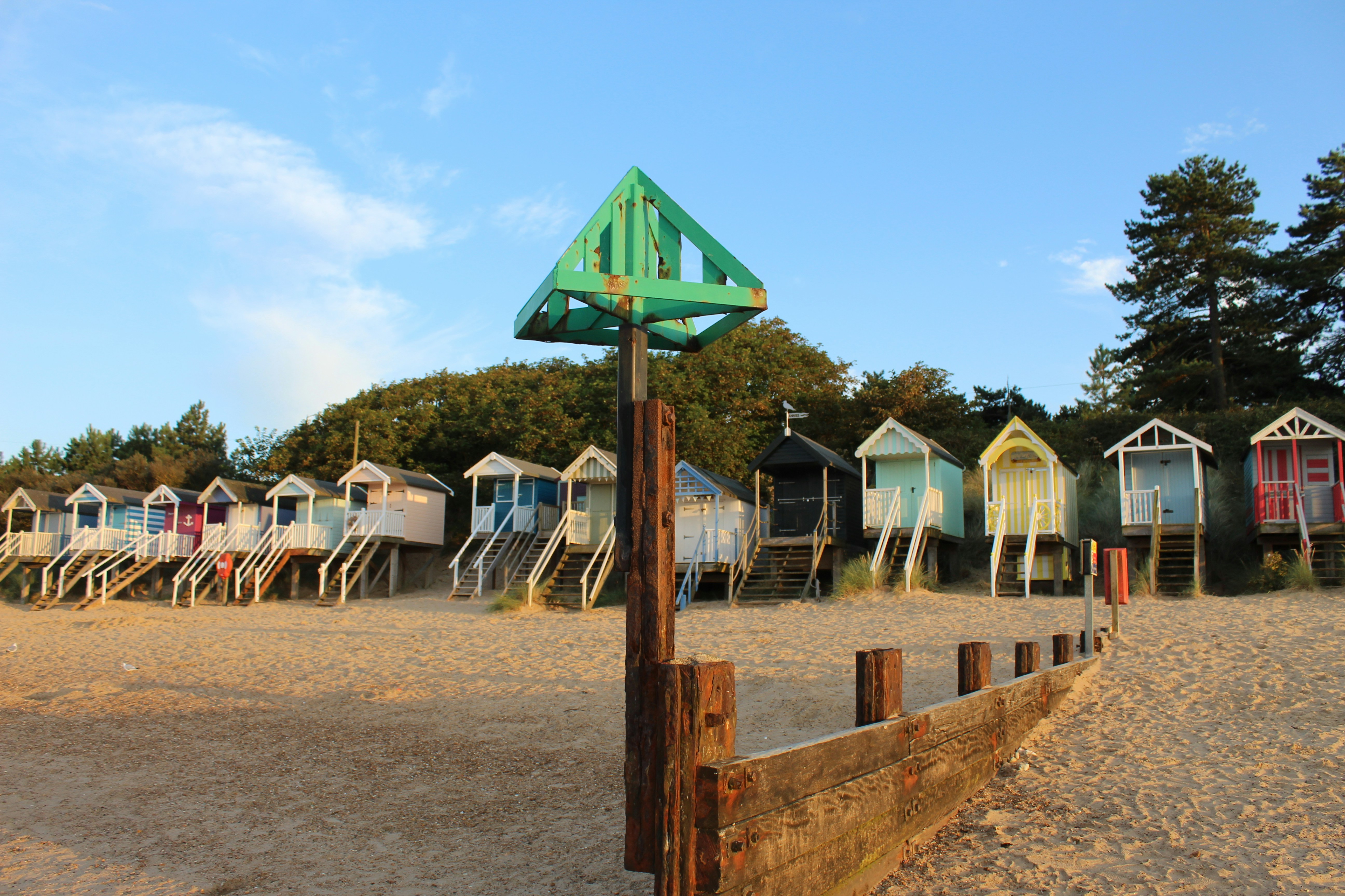A row of beach huts sitting on top of a sandy beach