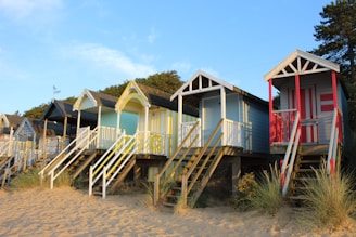 A row of beach huts sitting on top of a sandy beach