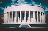 A white building with columns and a sky background