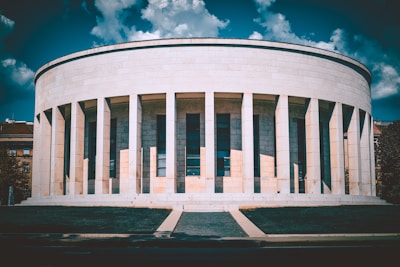 A white building with columns and a sky background