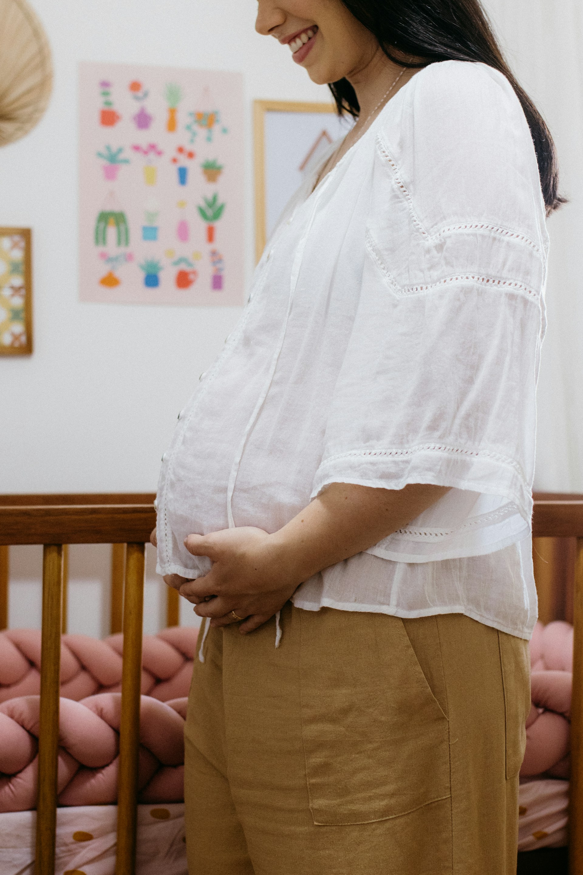 A pregnant woman standing in her crib