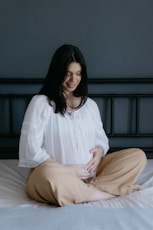 A woman sitting on top of a bed smiling