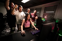 A group of people standing around a computer