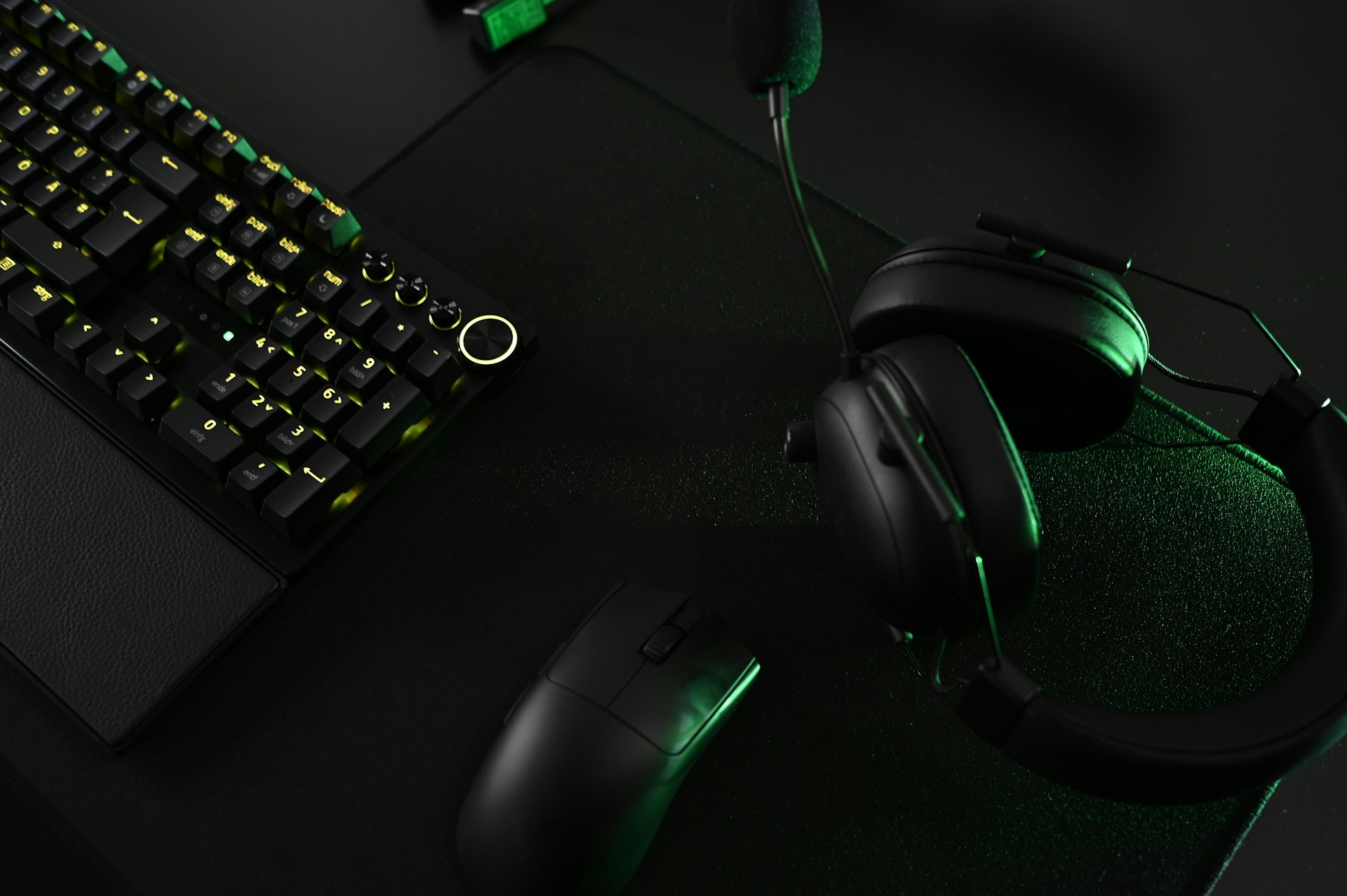 A close up of a keyboard and headphones on a desk