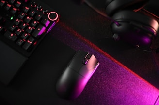 A computer keyboard, mouse, and headphones on a desk