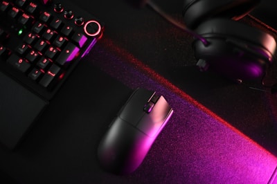 A computer keyboard, mouse, and headphones on a desk