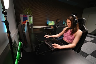 A woman sitting at a desk with headphones on