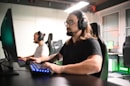 A man sitting at a computer with headphones on