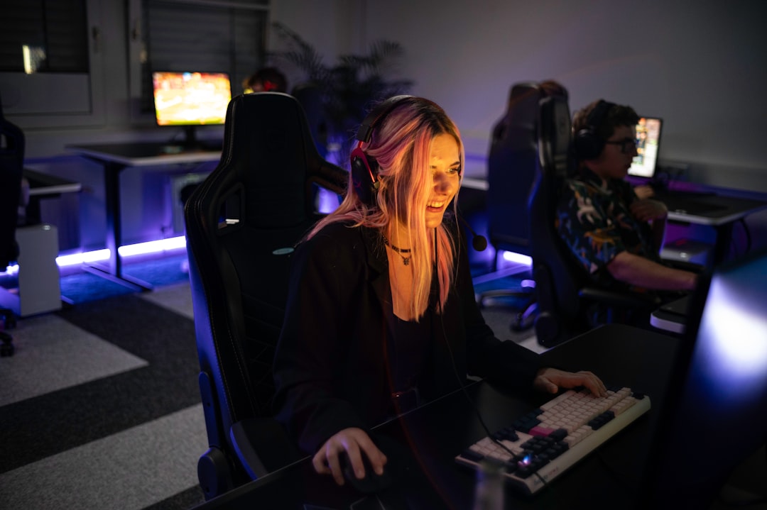 A woman sitting in front of a computer monitor, 1337Camp offers a unique environment perfectly tailored to the needs of gamers and creatives. Our facility features customizable lighting and LED floor lights that change colors to create the ideal atmosphere. The dojo-like design of the camp promotes a balance of relaxation and focus, allowing you to actively unwind while staying driven towards your goals. At 1337Camp, technology and design come together to create an inspiring and productive space that empowers you to reach your full potential.