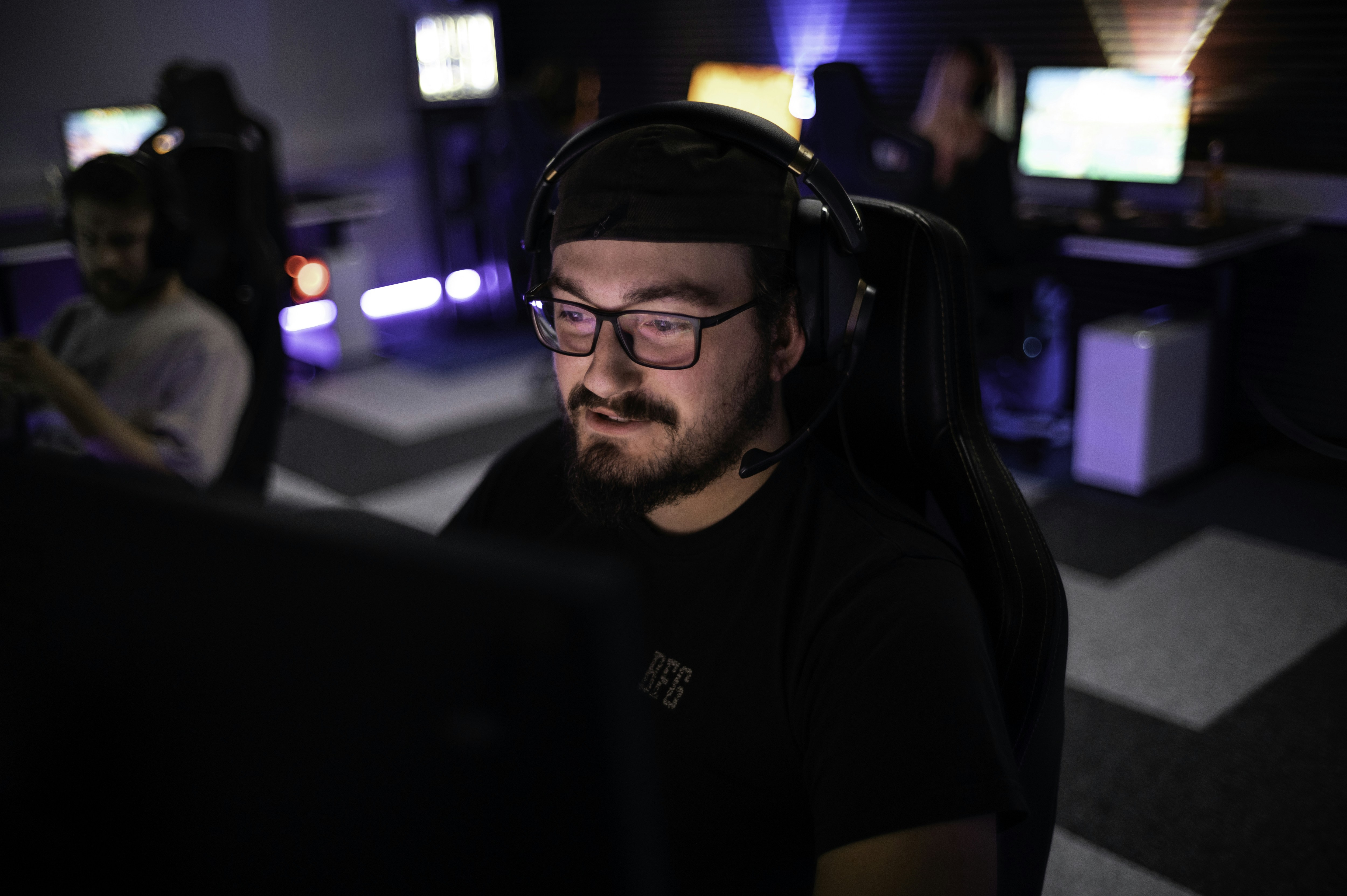 A man sitting in front of a laptop computer wearing headphones