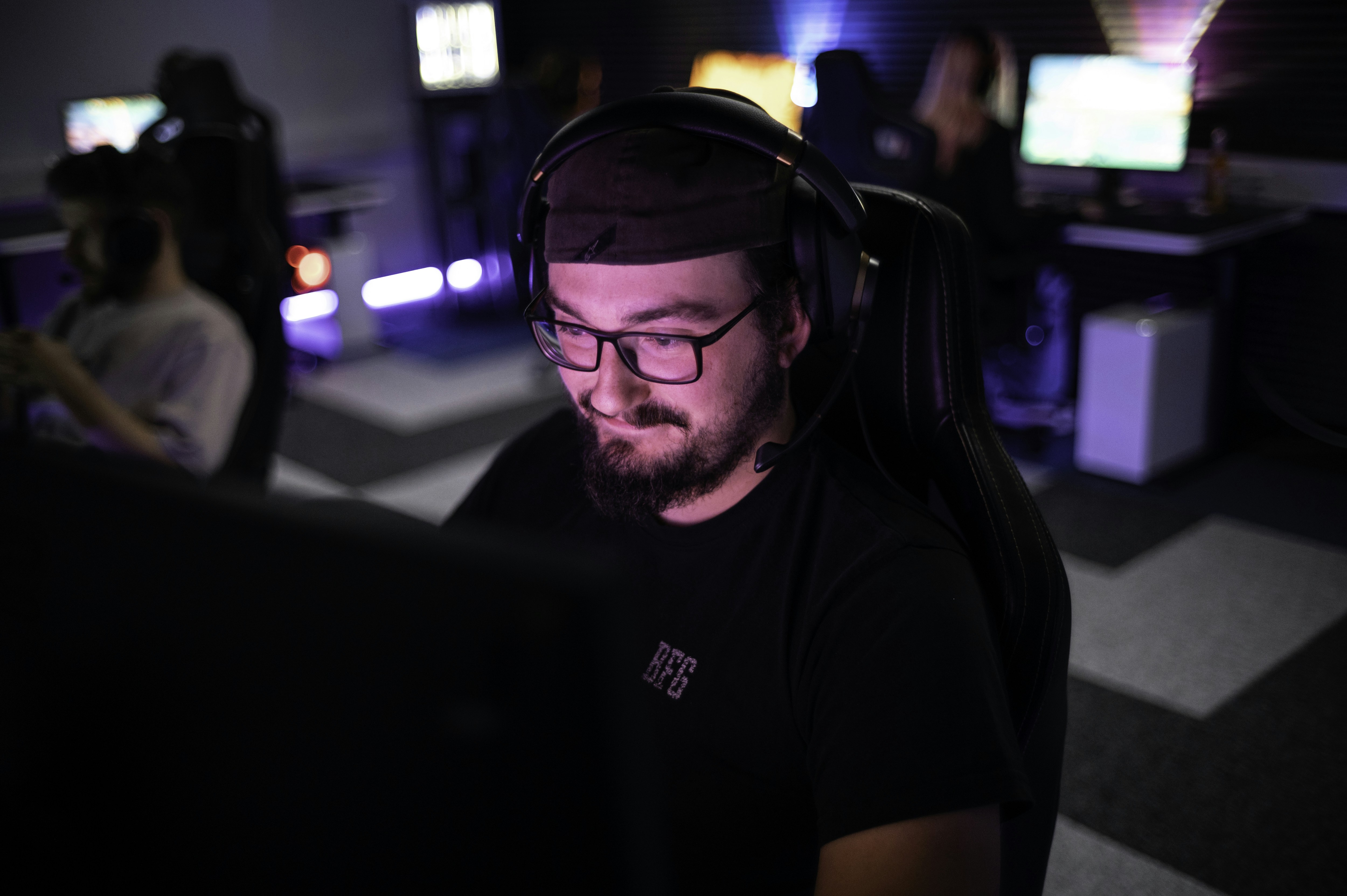 A man sitting in front of a laptop computer, 1337Camp offers a unique environment perfectly tailored to the needs of gamers and creatives. Our facility features customizable lighting and LED floor lights that change colors to create the ideal atmosphere. The dojo-like design of the camp promotes a balance of relaxation and focus, allowing you to actively unwind while staying driven towards your goals. At 1337Camp, technology and design come together to create an inspiring and productive space that empowers you to reach your full potential.