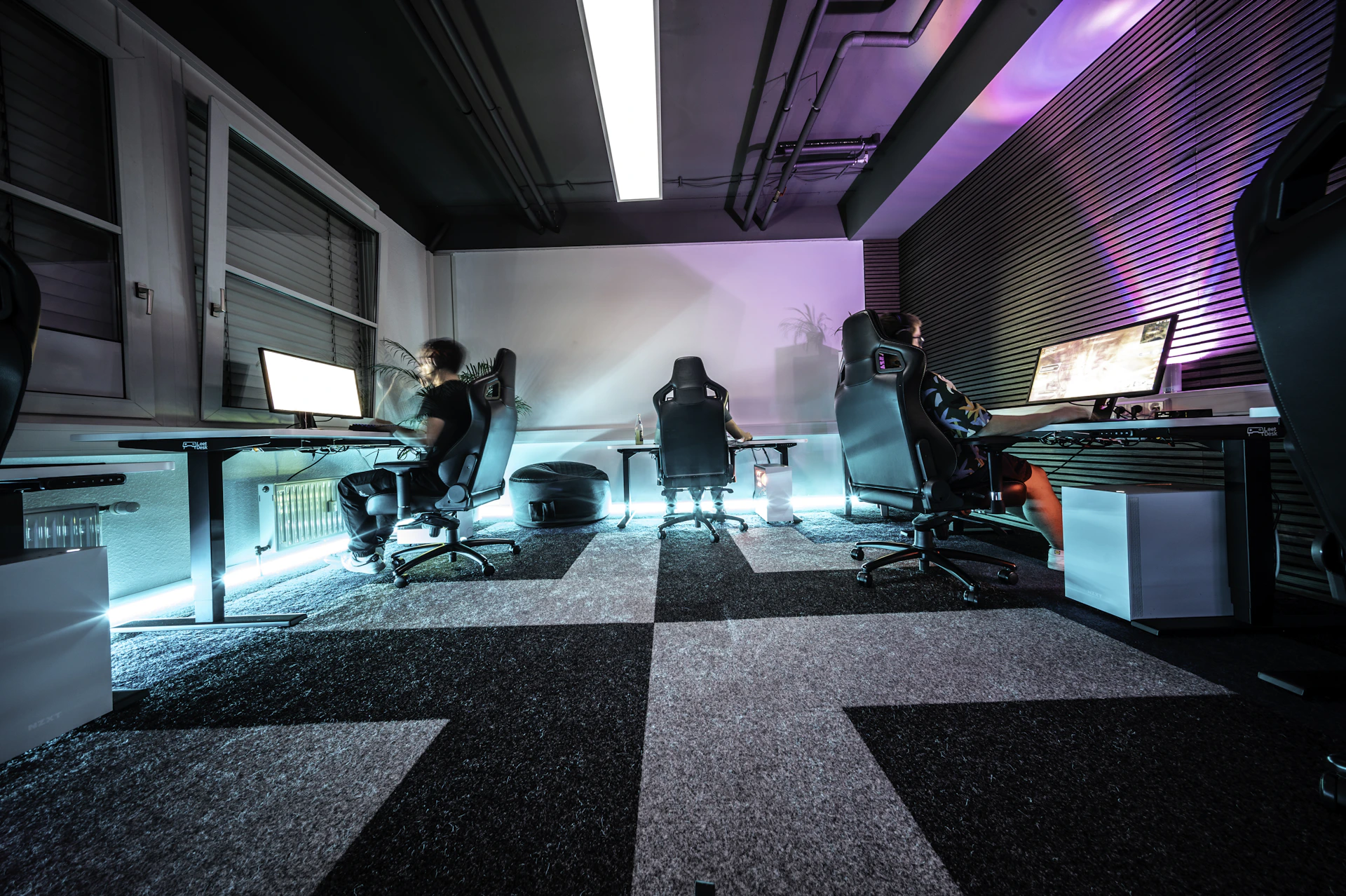 A group of people sitting around a computer desk