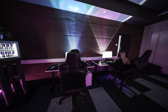 A man sitting in a chair in front of a monitor